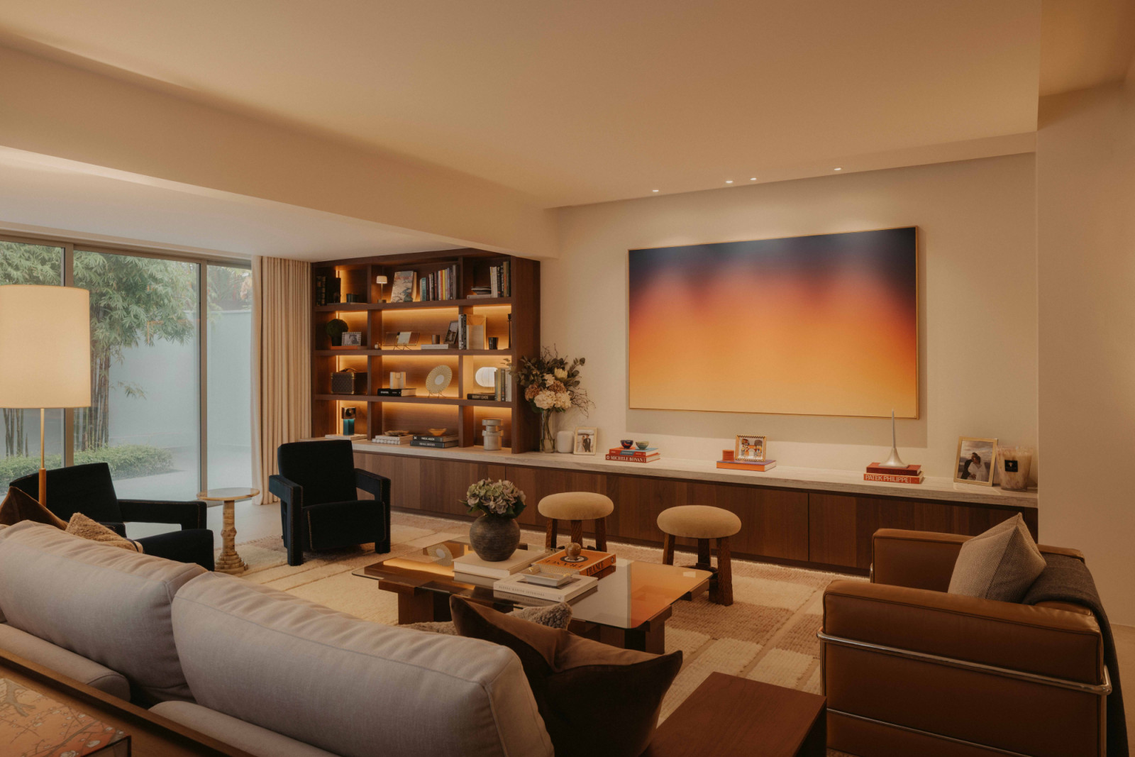 In the West Coast home’s living room, grey stone and walnut laminate meet a rust-and-beige carpet, anchored by a pair of deep cobalt Utrecht armchairs from Cassina