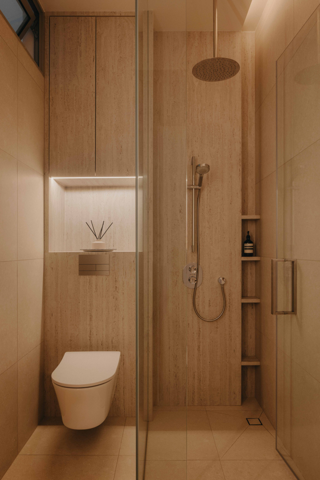 Beige-toned tiles line the shower and WC in this West Coast home, with a recessed niche and open shelving keeping the space clean and functional