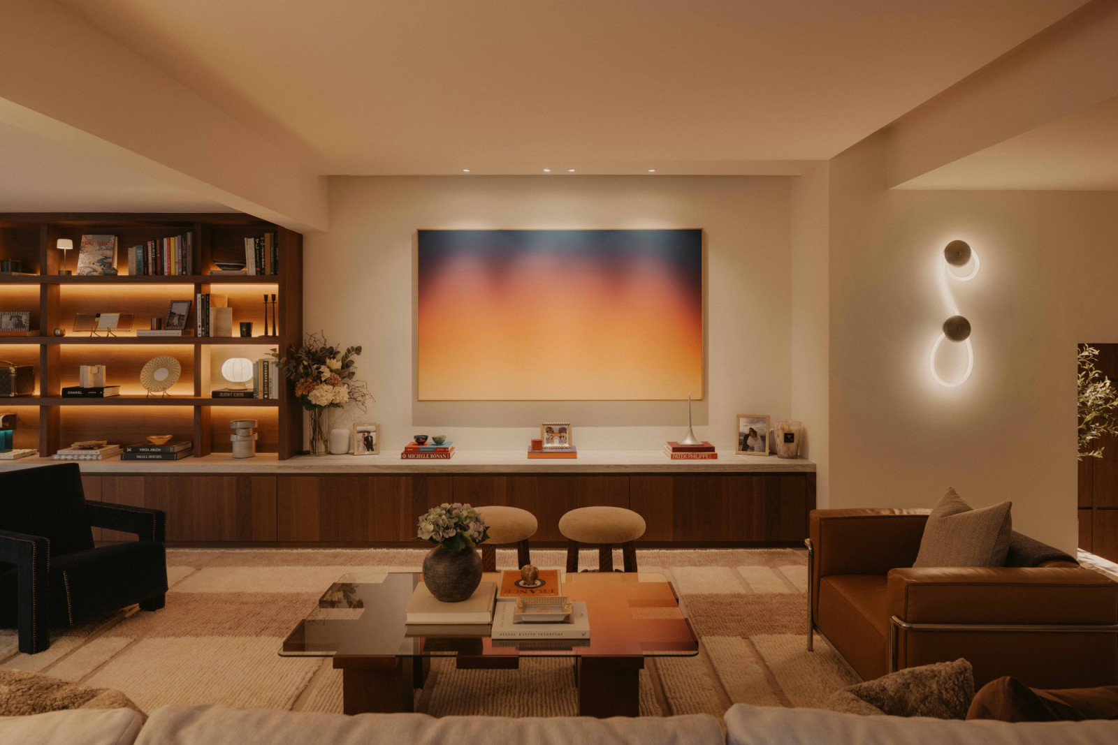 A sunset-hued painting by Jordan Tran-Kean takes pride of place in this renovated 40-year-old West Coast home’s living room;  there is no television, with a concealed projector transforming the space into a home cinema
