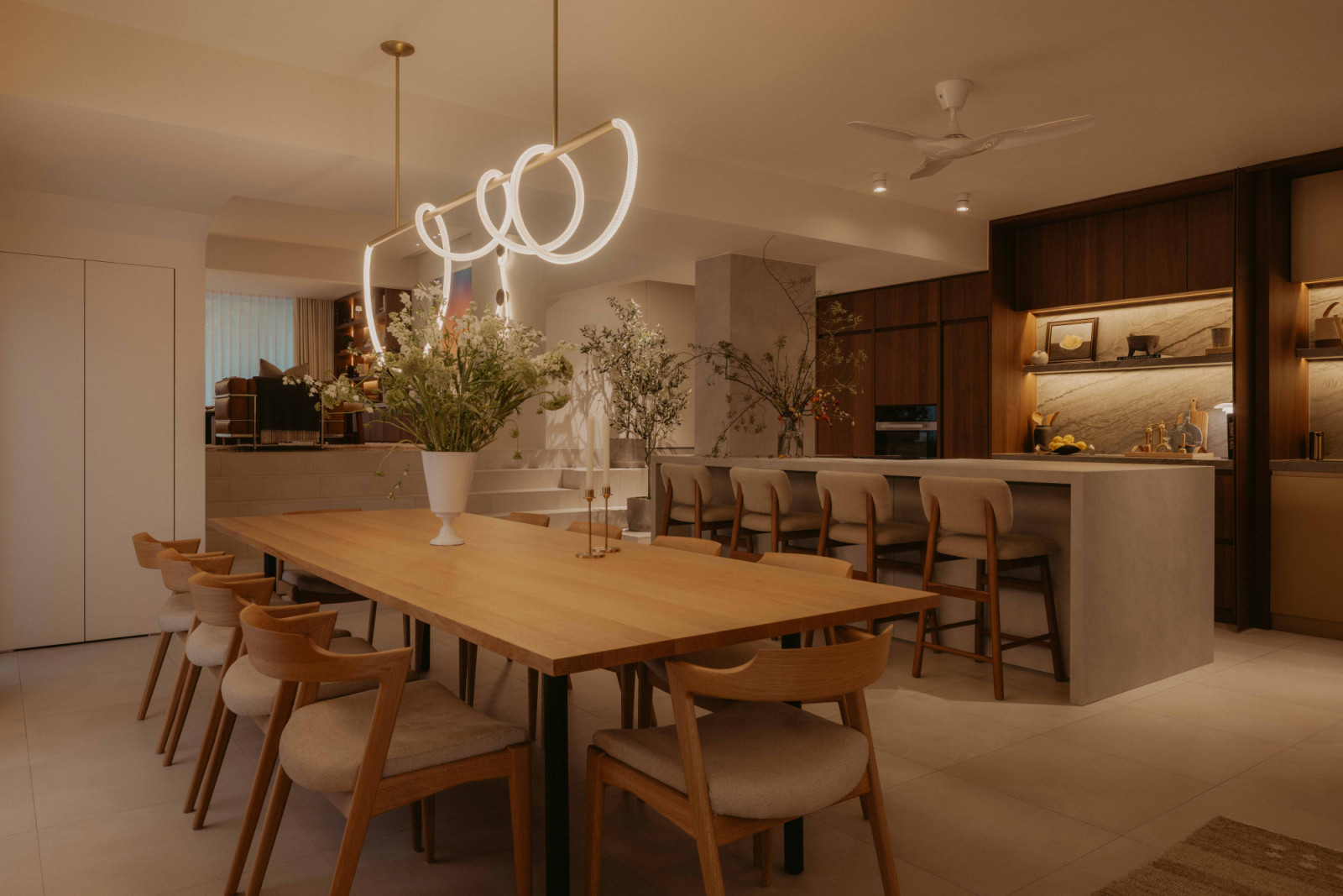 The entrance door opens directly to the dining room at the lower end of the plot, where a statement pendant from Luke Lamp Co introduces curves and softness to the space with its adjustable form