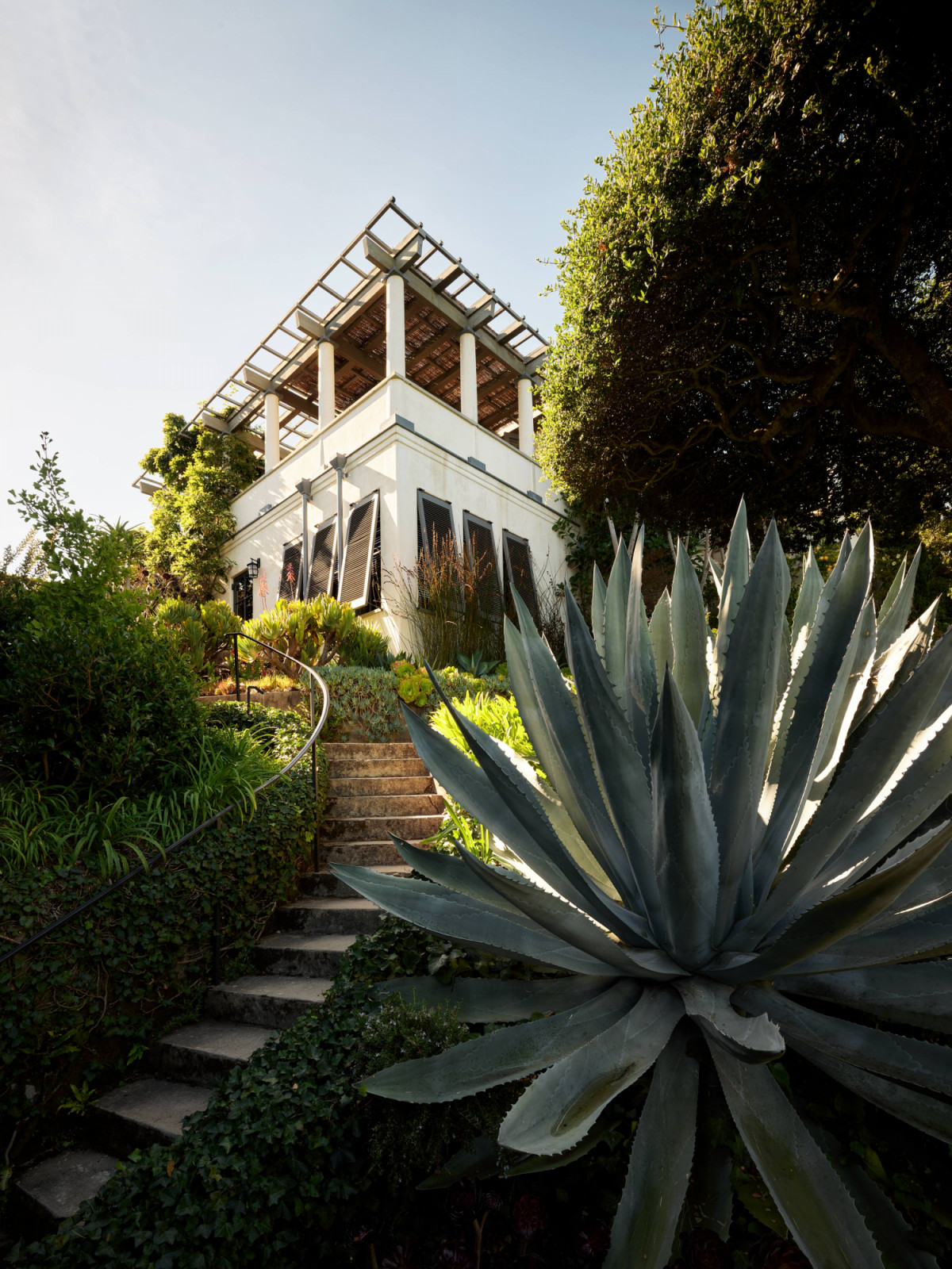 The home reveals itself slowly through the lush garden that surrounds the property