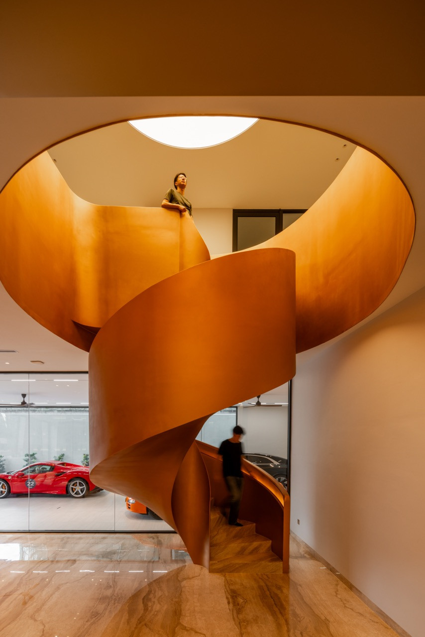 The bronze spiral staircase in the car lounge, seen from below with the circular atrium opening above