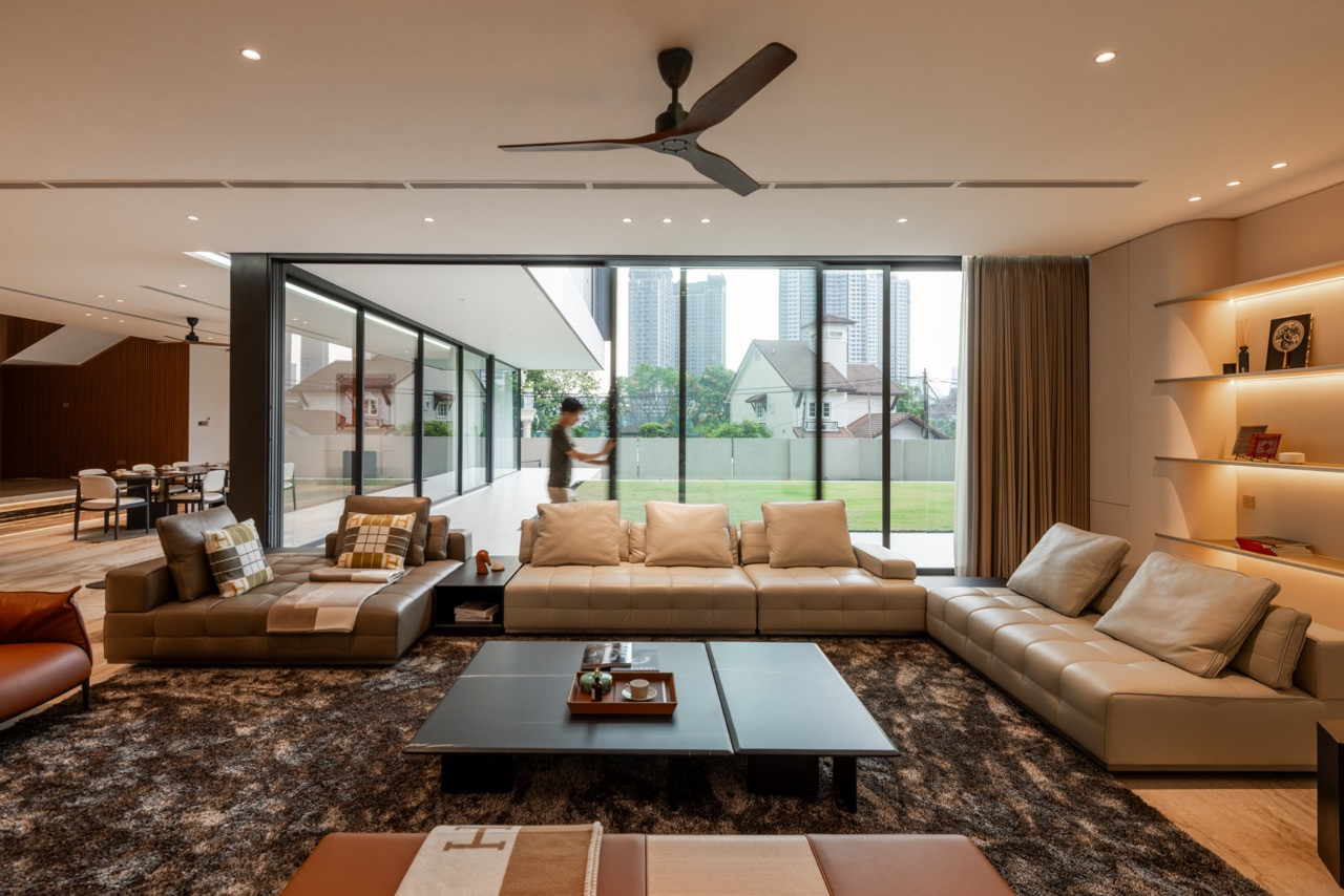 The living room facing the lawn, with the sliding glass doors open to the terrace and the dining area visible to the left