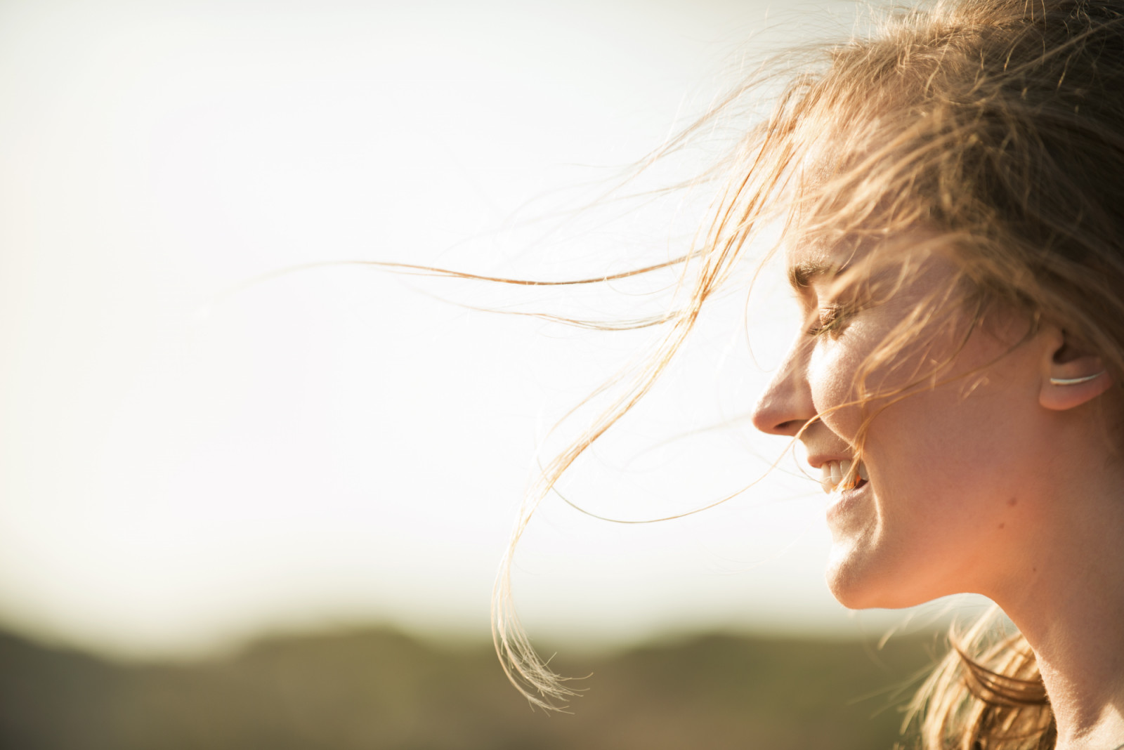Attractive woman enjoying the fresh air while the wind blows in her hair