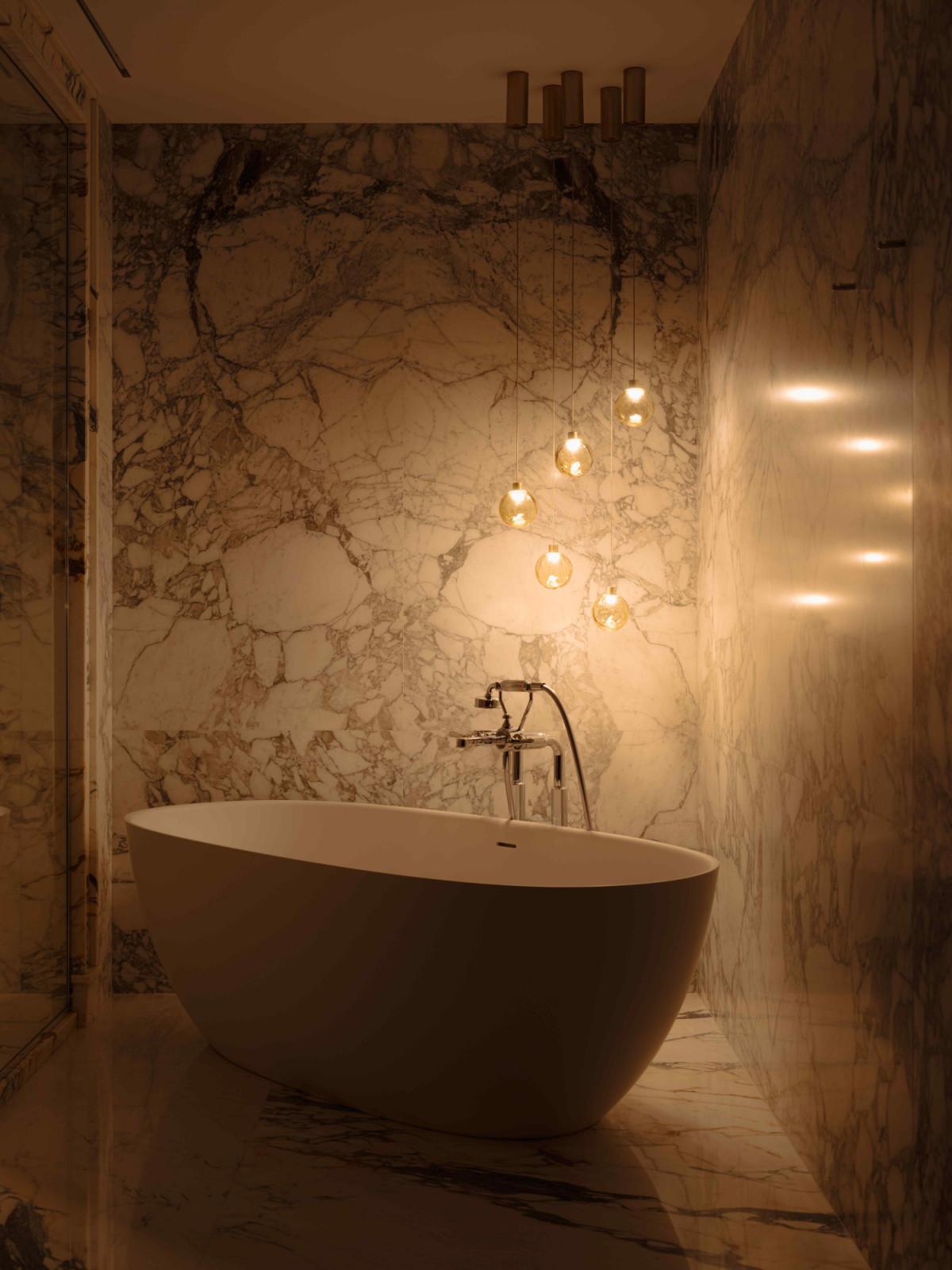 The moody bathtub area, featuring a PAA standalone bathtub and Panzeri pendant lamps