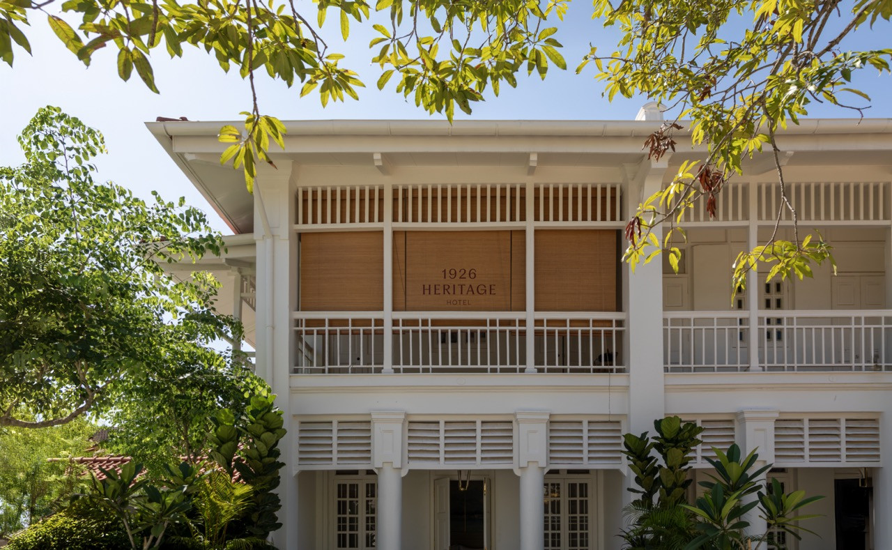 The upper floor facade of the 1926 Heritage Hotel, with the hotel’s signage set against warm honey-toned louvred shutters and the original timber balustrade of the covered verandah