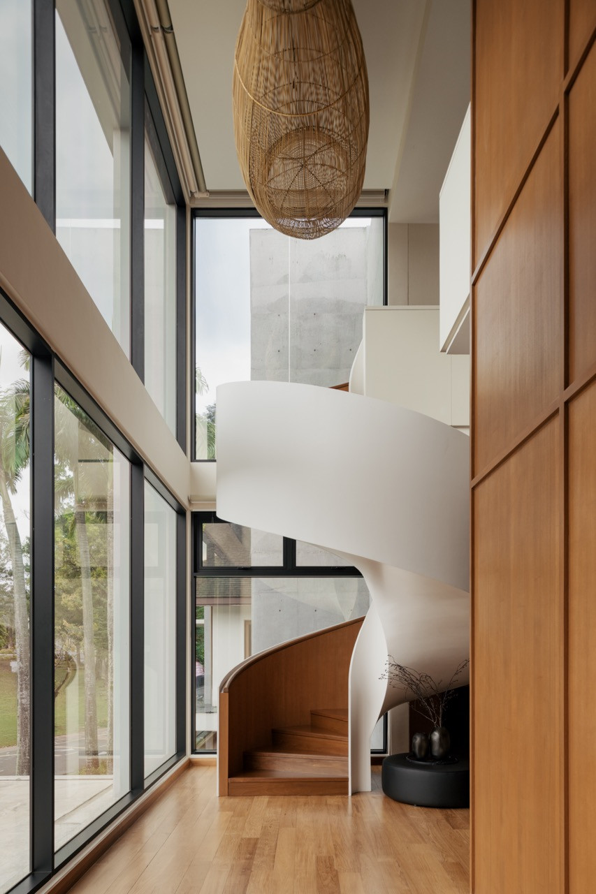 The sculptural spiral staircase, paired with the custom thirty-foot rattan pendant installation, produced in collaboration with local supplier Rattan Art, within the double-volume void of JT House