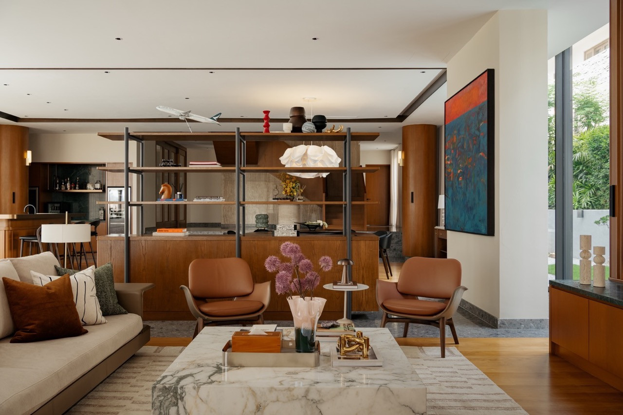The living room of JT House, with the open shelving unit and abstract painting anchoring the central zone, and the dry kitchen and bar
