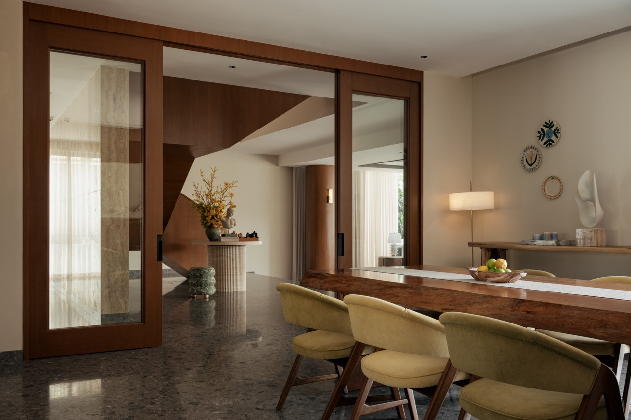 Timber-framed sliding glass doors connect the family dining area to the foyer and staircase hall on the ground floor