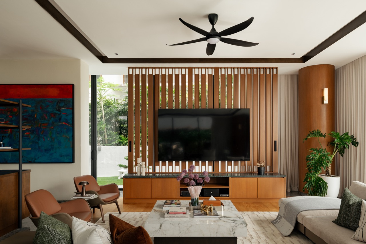 he living room opens to the private landscaping through full-height glazed doors, with a timber slatted screen housing the television unit