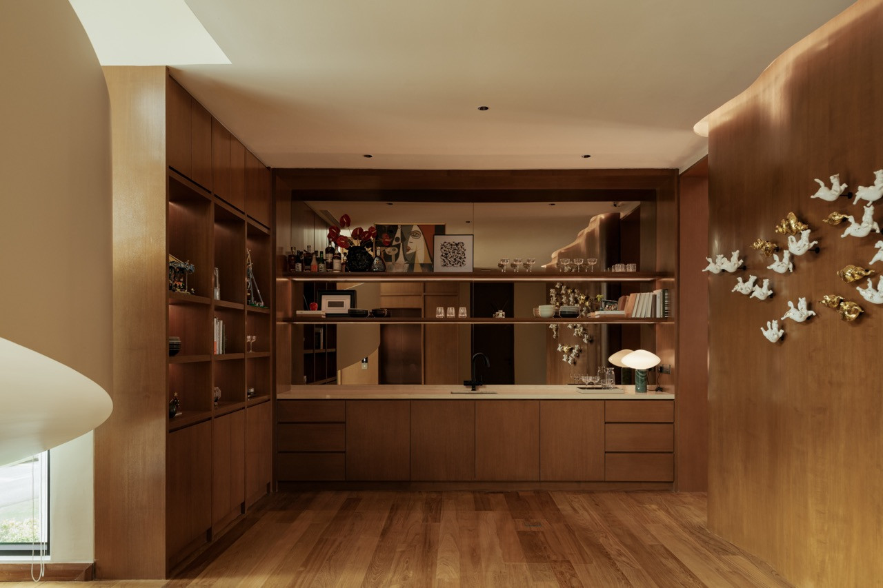 The bar and shelving area of the entertainment lounge on the first floor, with the figurine wall installation visible at right