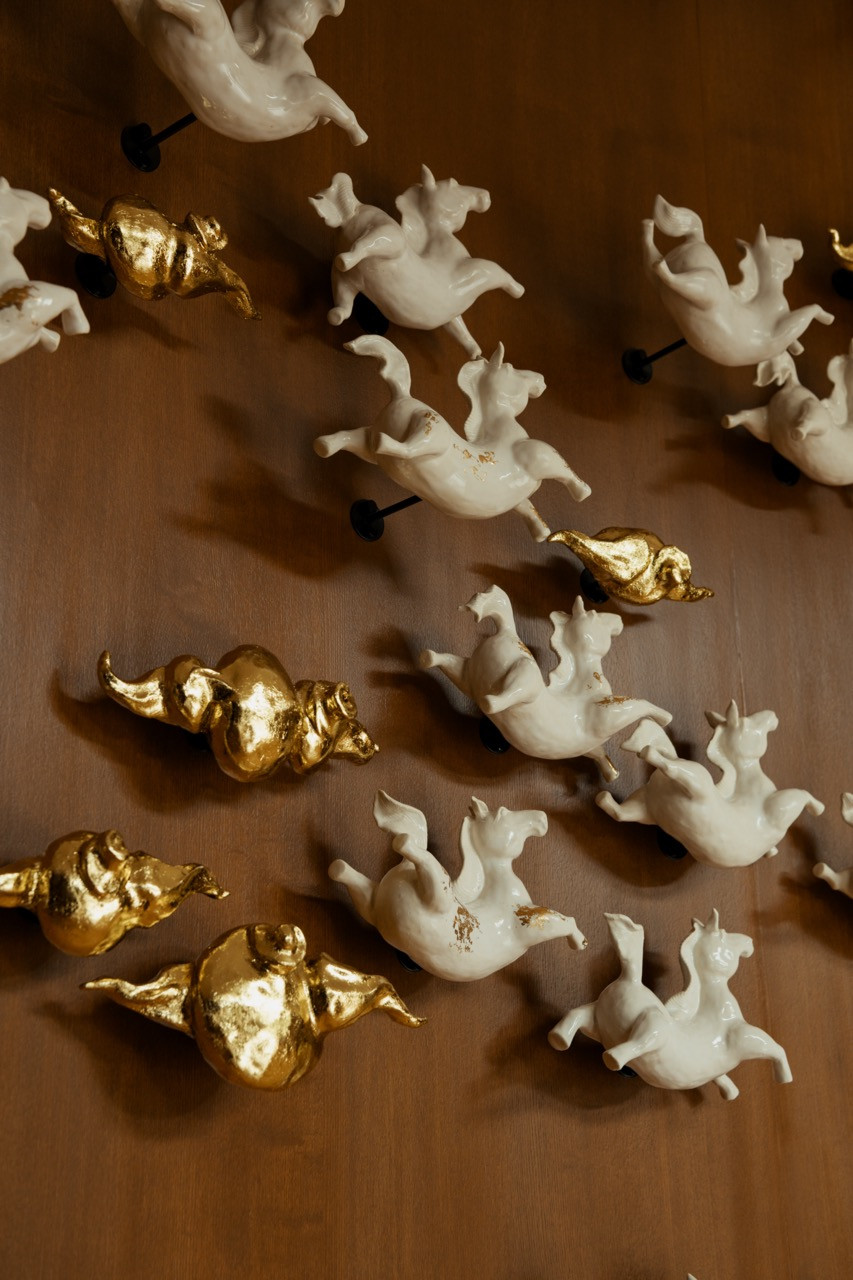 Detail of the white and gold figurine wall installation in the entertainment lounge on the first floor