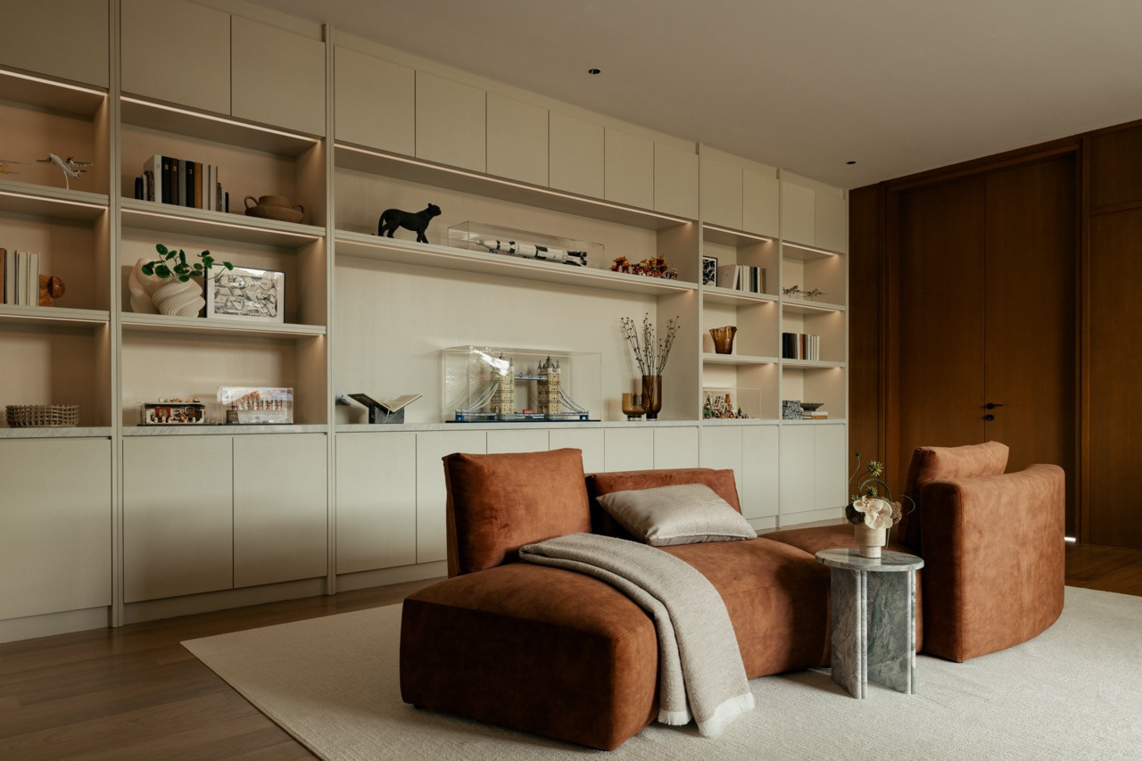 A children's room on the second floor with a full-height built-in shelving unit in a pale finish