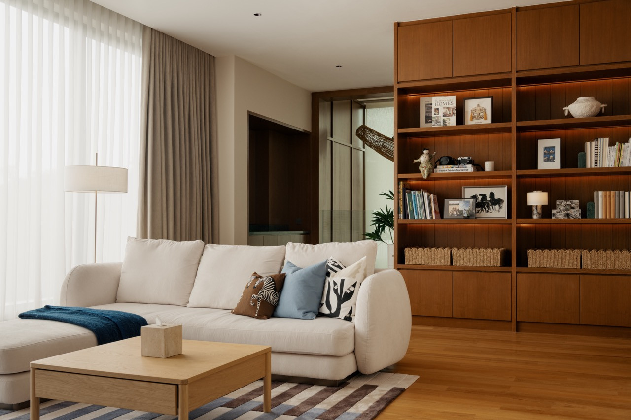 A wider view of the entertainment lounge on the first floor, with full-height timber shelving and solid timber flooring