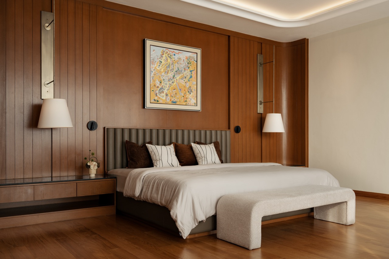 The master suite on the second floor with vertical timber wall panelling, an upholstered headboard and solid timber flooring
