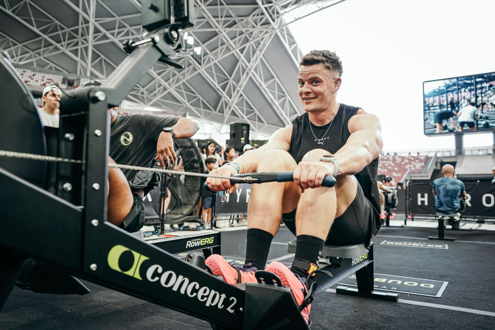 A throwback photo of Pete Laverick mid-workout during a Hyrox race, showing him in a focused athletic stance during a functional movement.