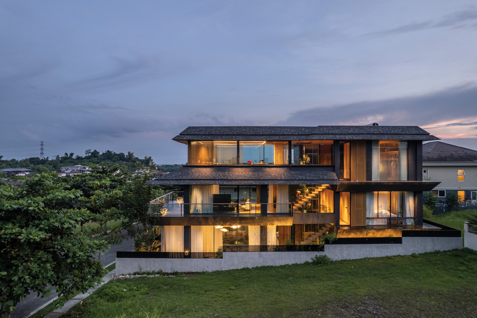 The view from the west side shows the house beautifully sloping, following its terrain. The uneven levels created by the half-storeys create a subliminal visual movement