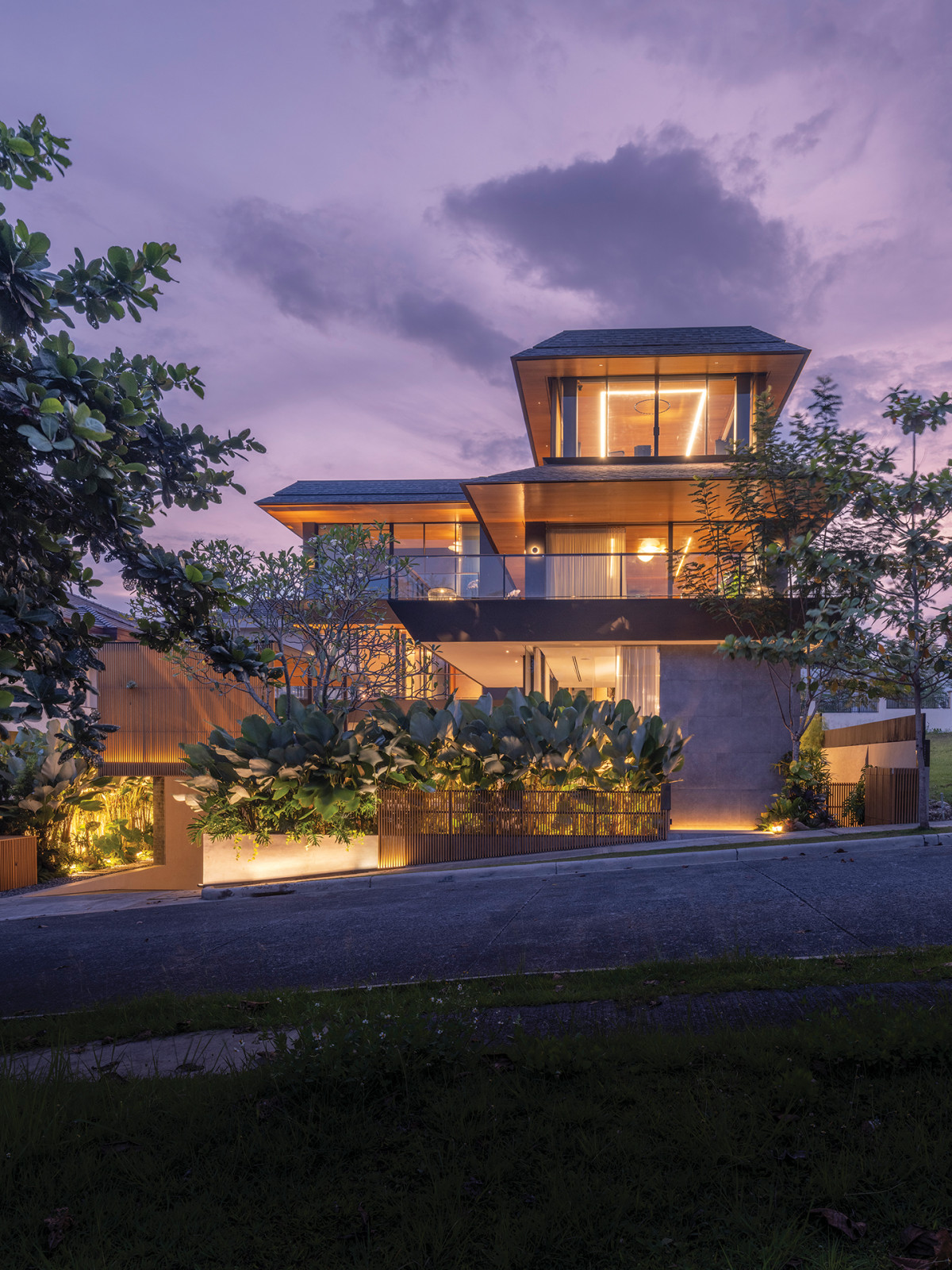 The view from street level shows the house’s aperture design featuring eaves tilted upward, the architect’s technique to bring the light in