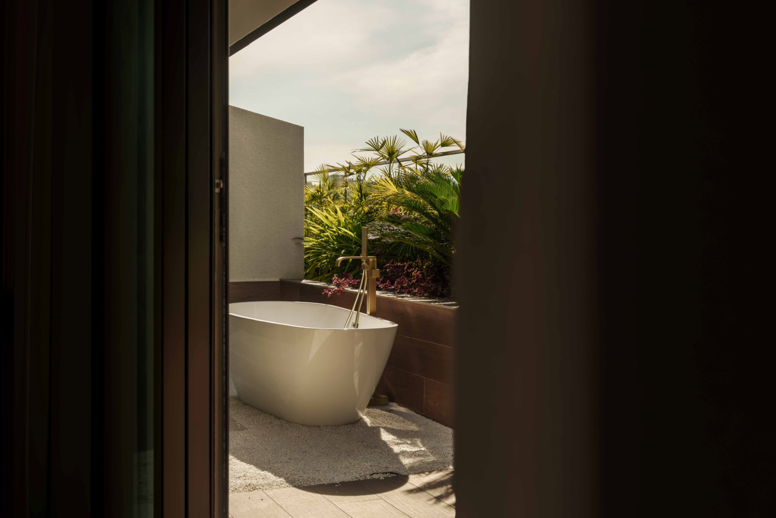 Foliage casts dappled sunlight on the spa-like outdoor bath area
