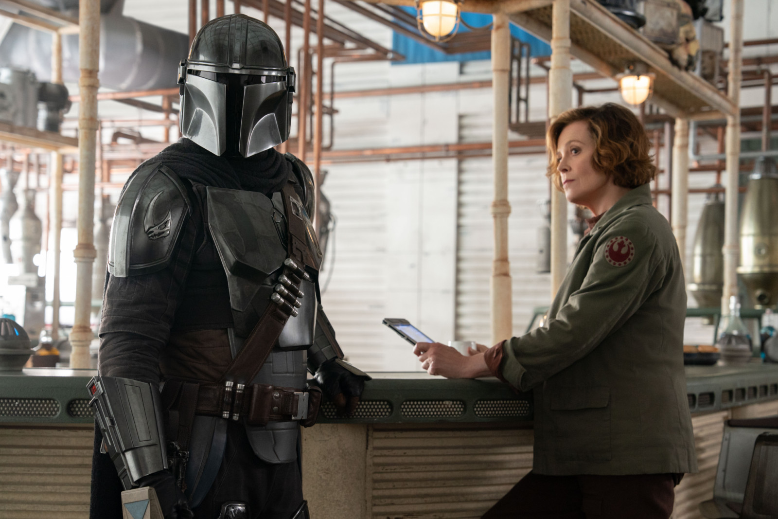 (L-R) Mandalorian (Pedro Pascal) and Colonel Ward (Sigourney Weaver) in Lucasfilm's THE MANDALORIAN AND GROGU. Photo by Justin Lubin. © 2026 Lucasfilm Ltd™. All Rights Reserved.