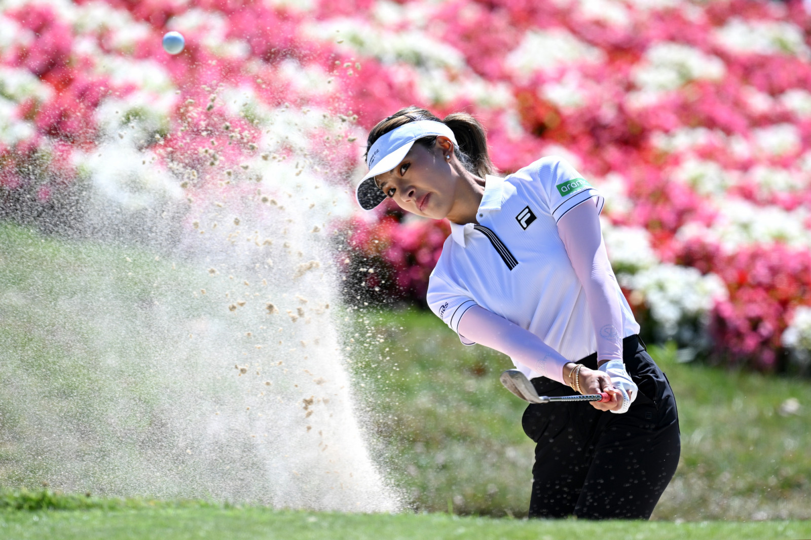 EVIAN-LES-BAINS, FRANCE - JULY 10: Muni He of China plays a shot from a bunker on the fifth hole during Round One of The Amundi Evian Championship 2025 at Evian Resort Golf Club on July 10, 2025 in Evian-les-Bains, France. (Photo by Stuart Franklin/Getty Images)