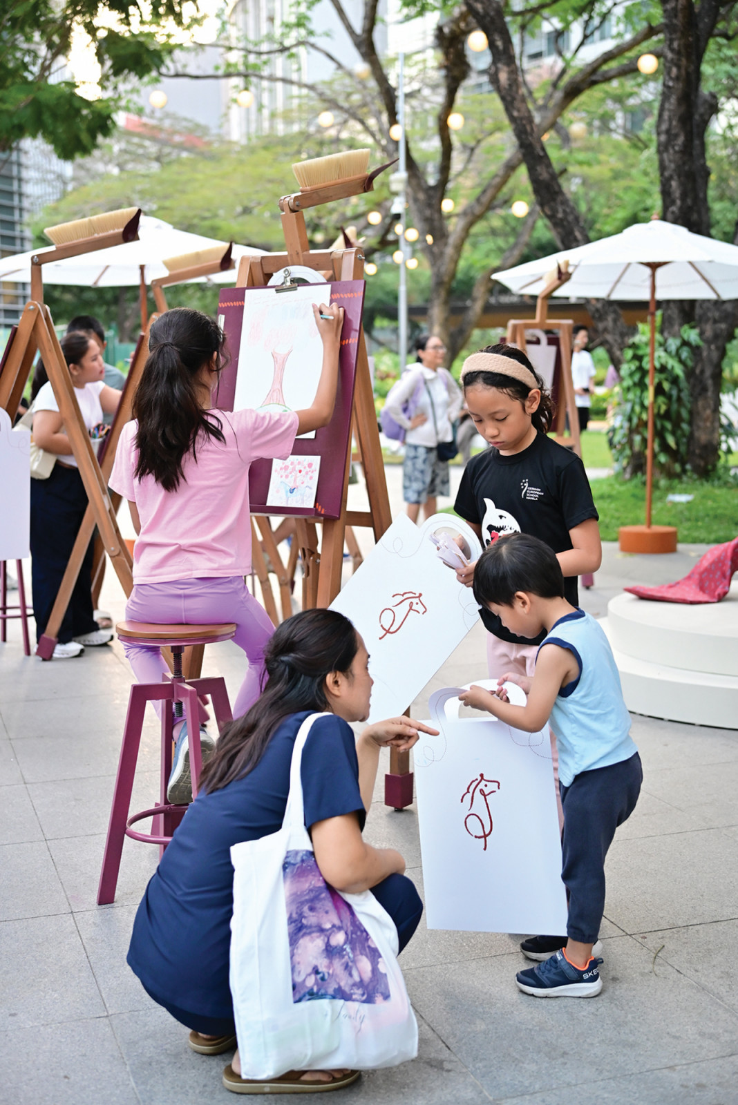 Visitors taking home their finished artwork from the Hermès, 'Drawn to Craft' event