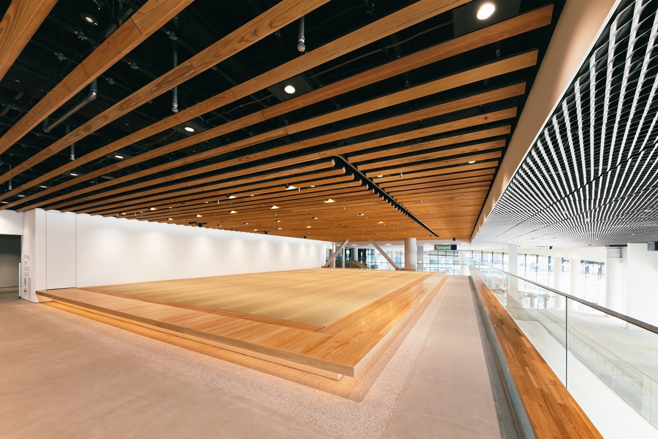 A flexible event hall on one of the museum’s lower floors, lined with exposed timber ceiling beams and a raised tatami platform (Photo: Yasuyuki Takaki)