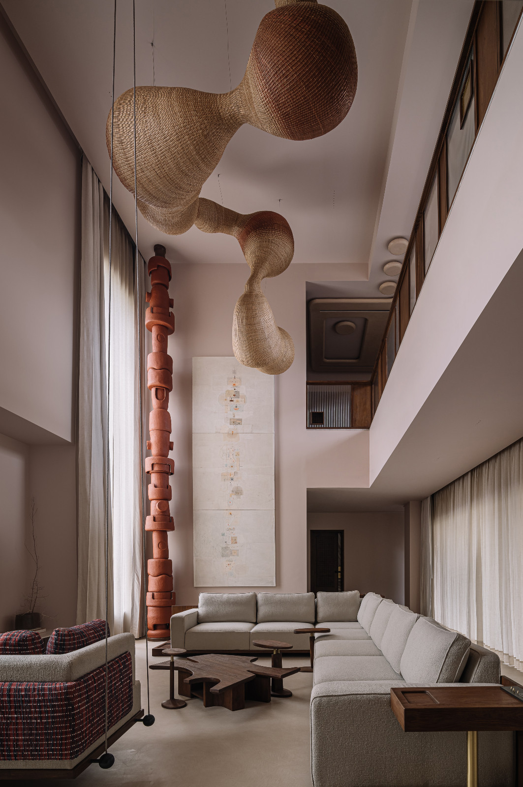The double-height ceiling in the living room of a family home in Navsari, India designed by Veeram Shah of Design Ni Dukaan