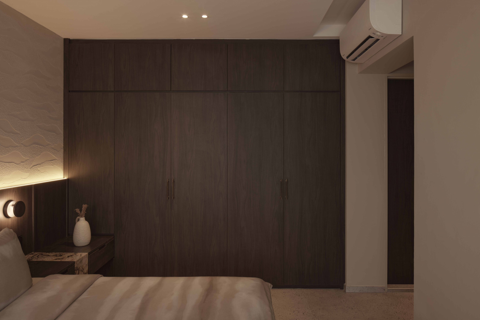 Matte carpentry finishes and honed marble surfaces reduce glare and hide wear