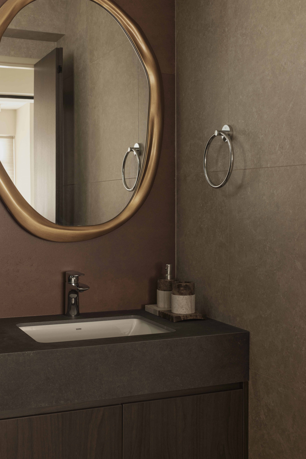 An irregularly shaped mirror in the bathroom adds personality