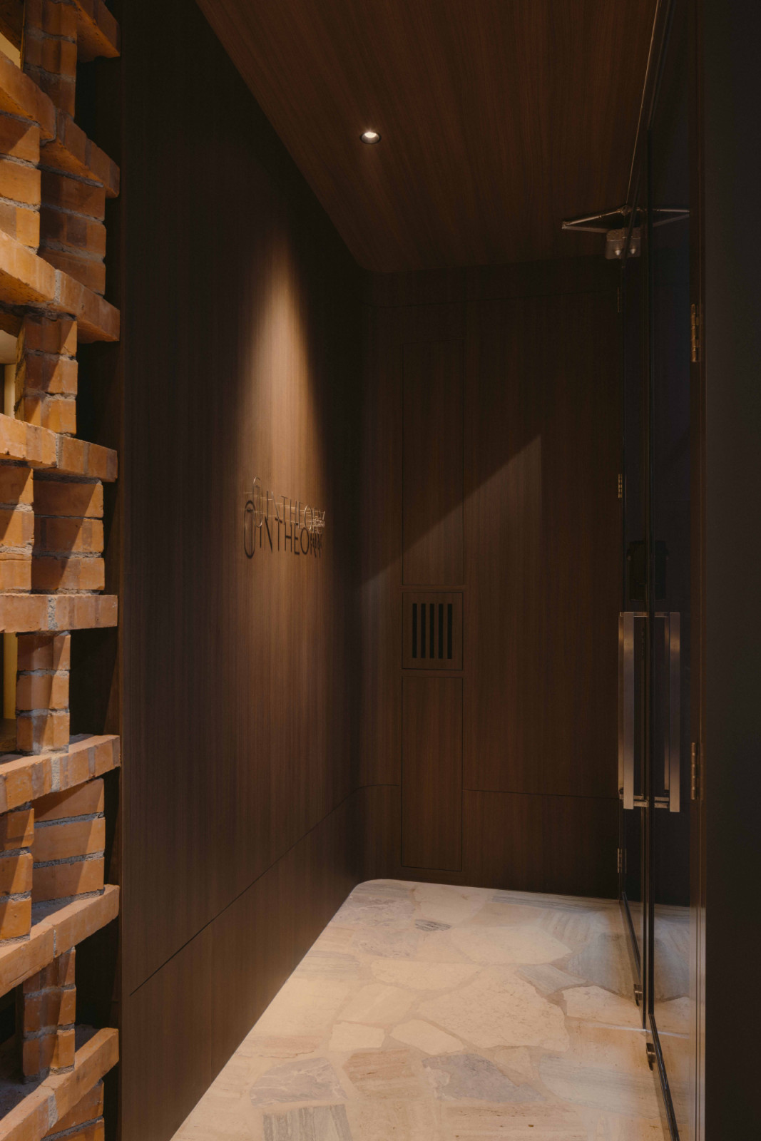 A tactile entrance made from salvaged marble and reclaimed brick sets the tone