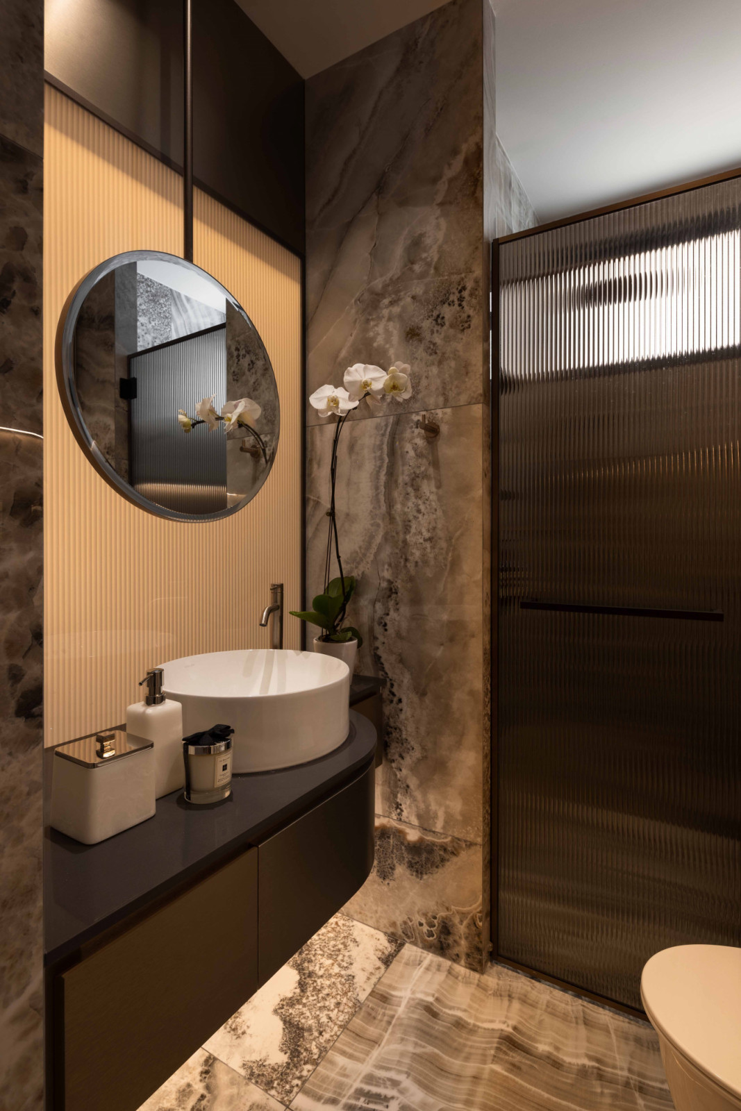 Fluted glass was used in place of solid walls in the bathrooms, allowing natural light to filter into the space while preserving privacy