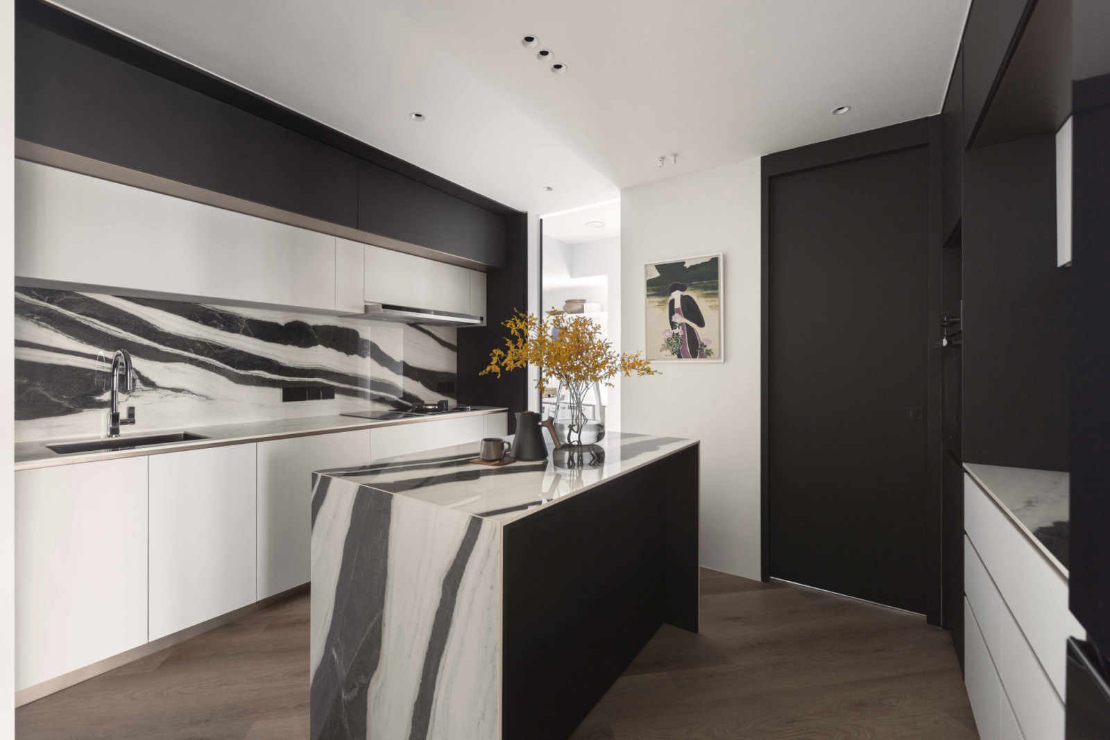 Bold black veining in the porcelain slabs create a striking graphic statement within the open-plan layout