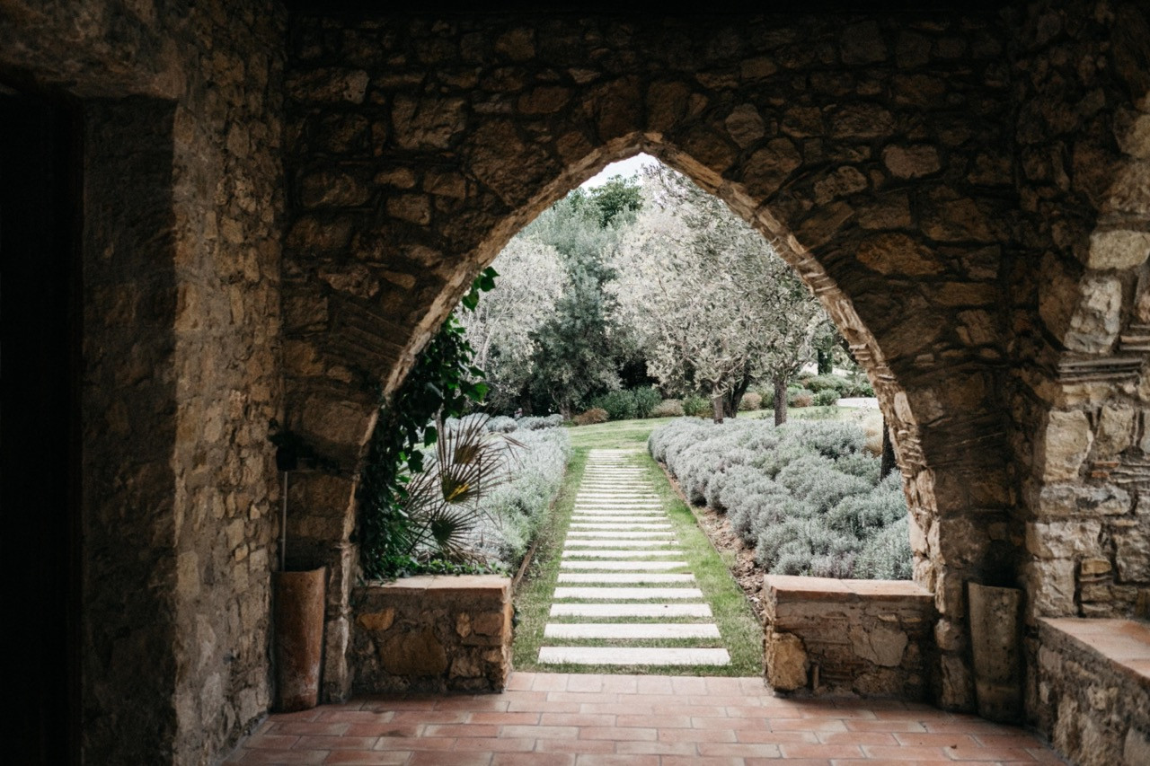 The restored stone chapel with terracotta tile flooring, original timber ceiling beams and a stone arch