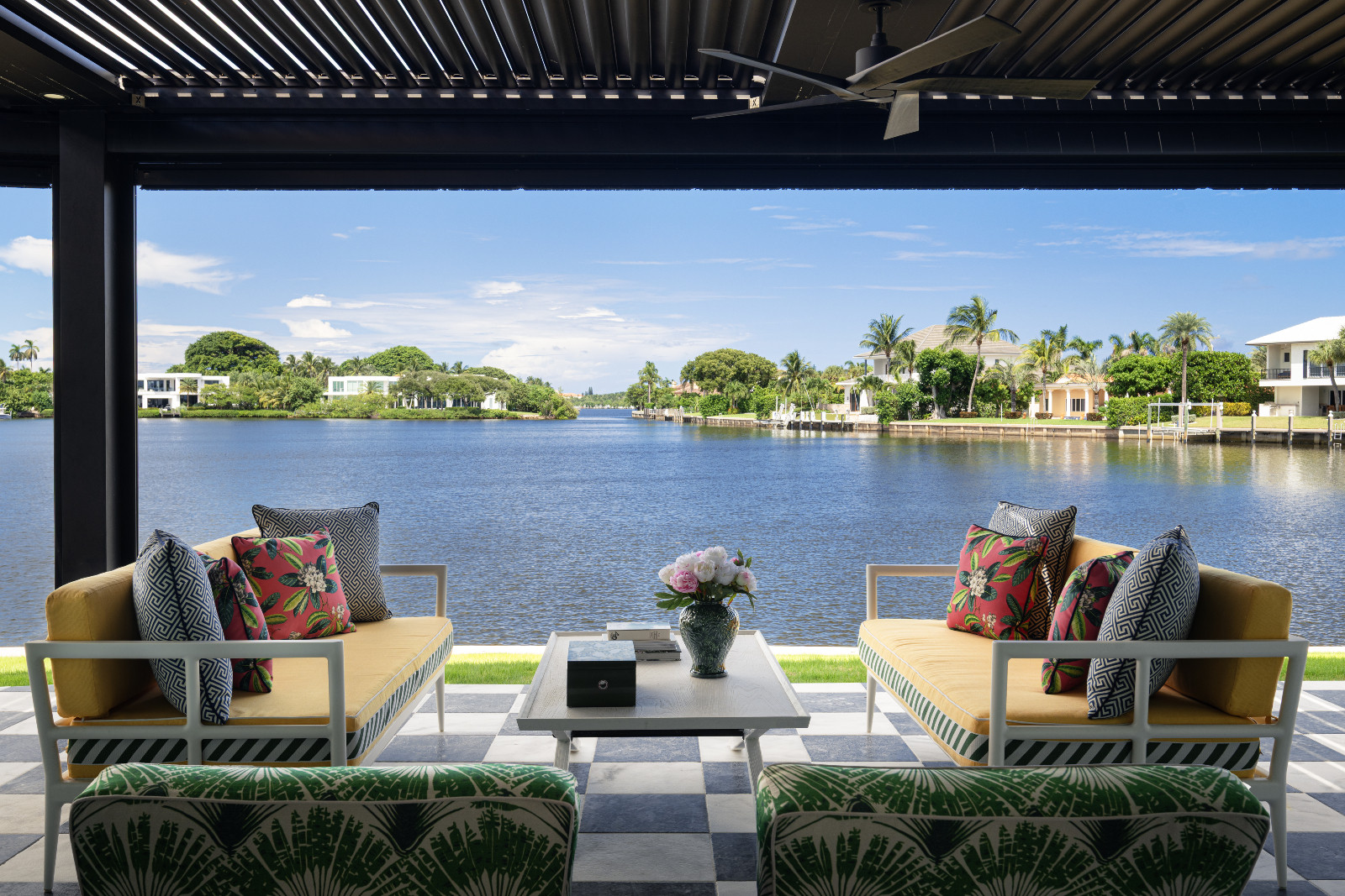 Waterfront views from the outdoor lounge of a maximalist, eclectic Florida home designed by Mr Alex Tate