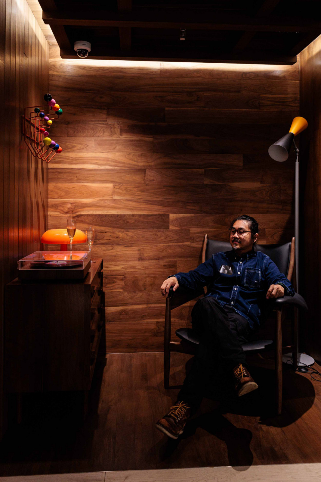 Don Wong seated in the mid-century modern vignette within Wood Culture