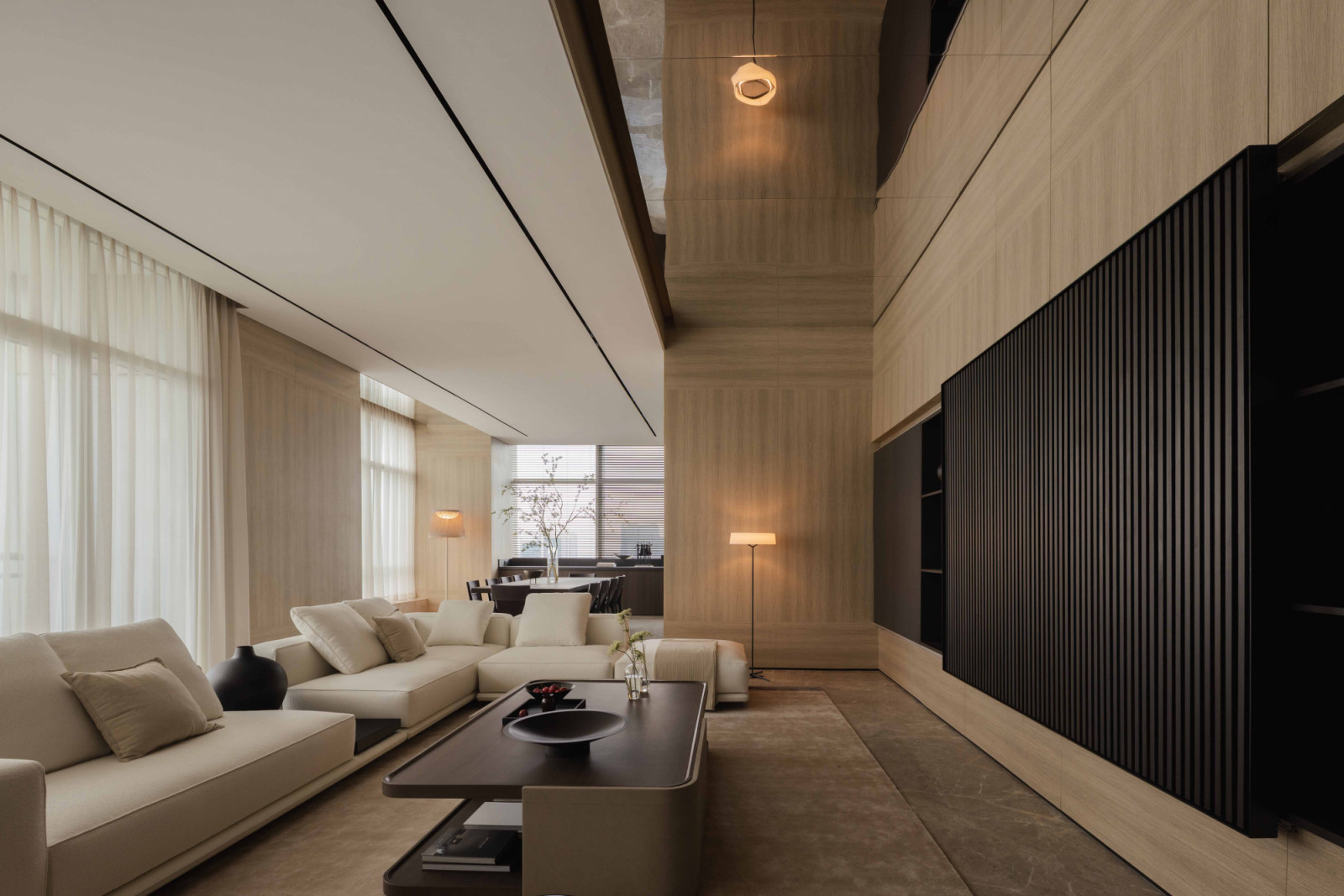 Oak timber laminate surfaces and dark ribbed panelling give the living room its warm, refined character.