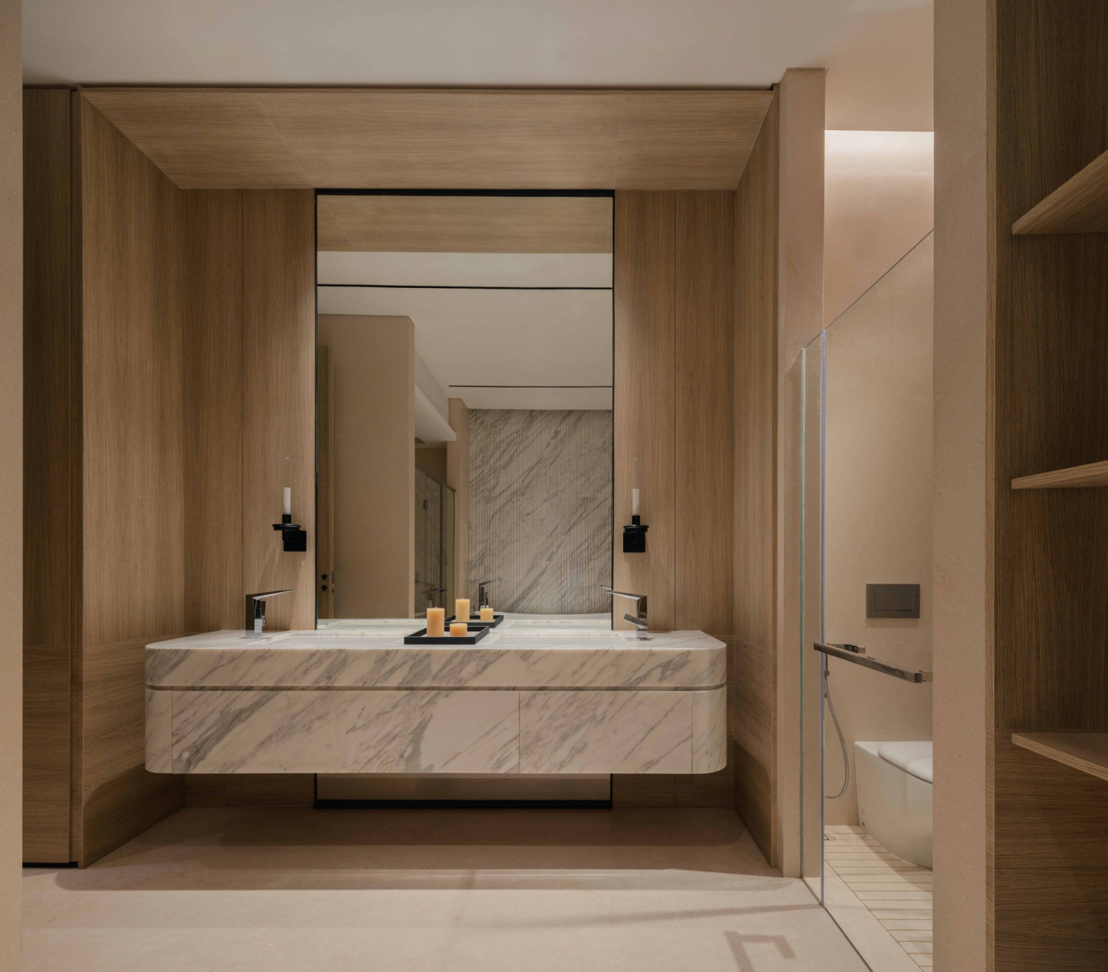 Twin vanities in statuario white marble sit within a timber-framed surround in the master bathroom