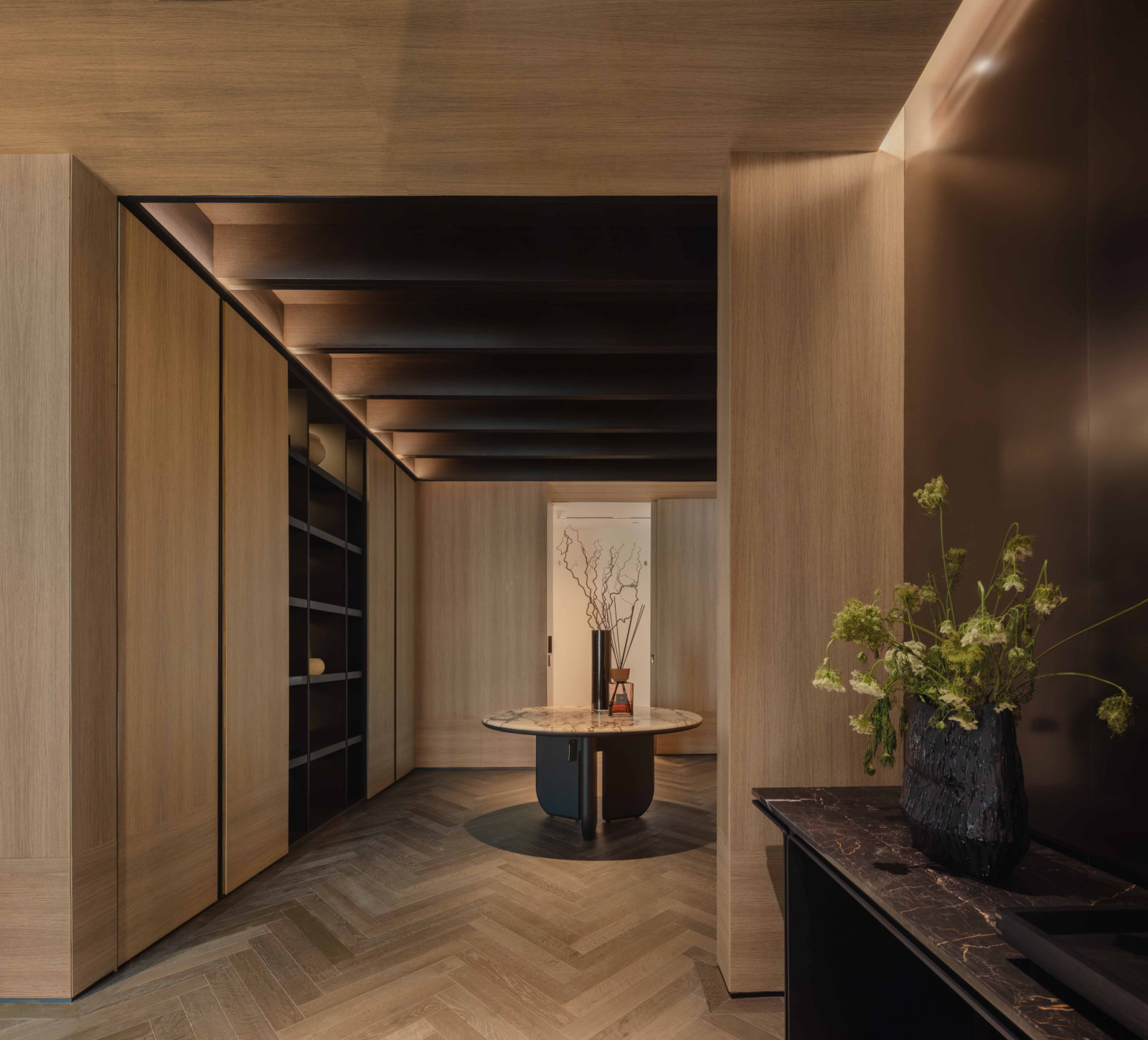 The foyer sets an intimate mood with dark timber-clad ceilings and a herringbone timber floor