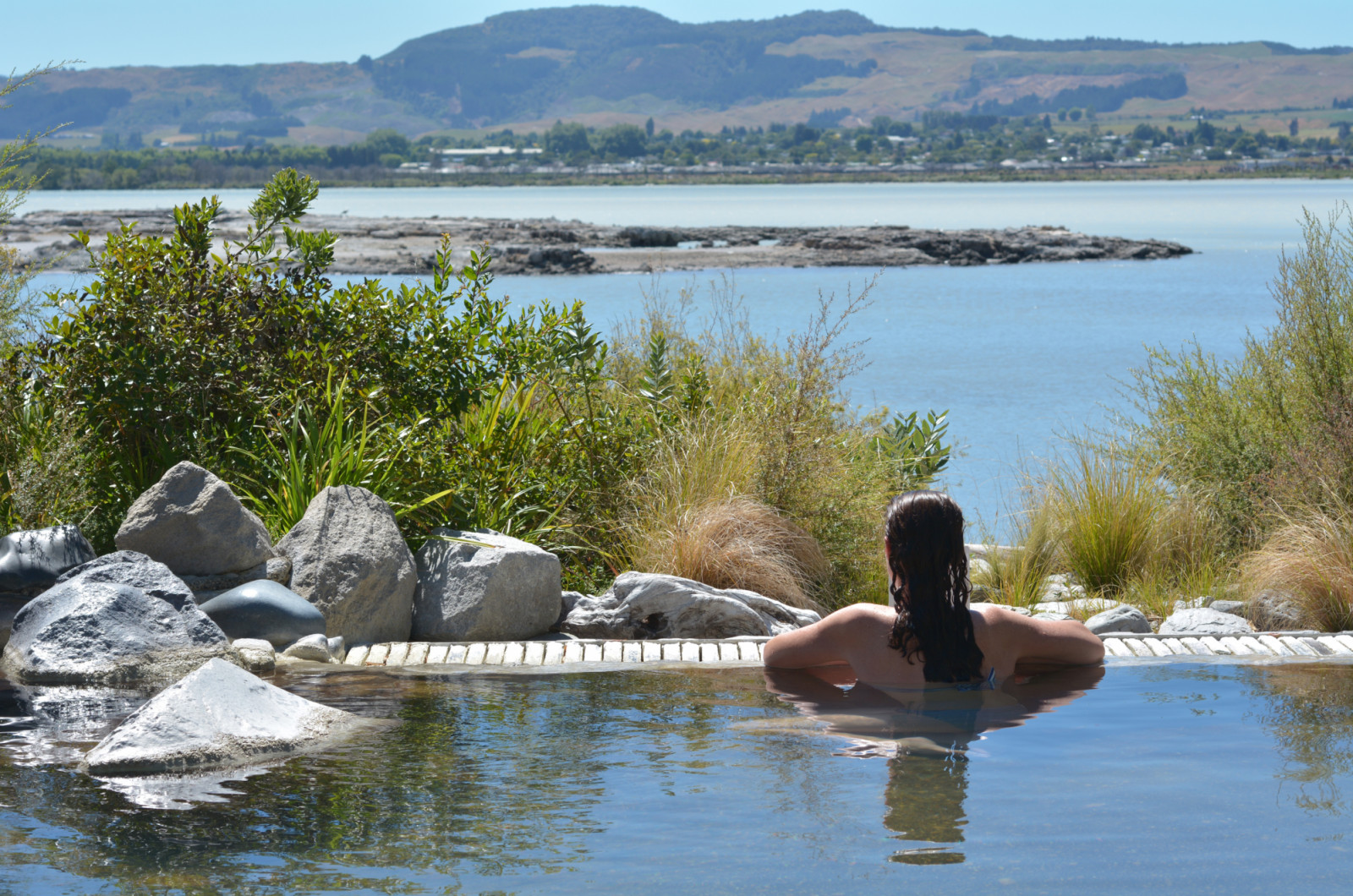 Young woman having a spa in outdoors hot pool in Rotorua, New Zealand. (Photo: chameleonseye / Getty Images)