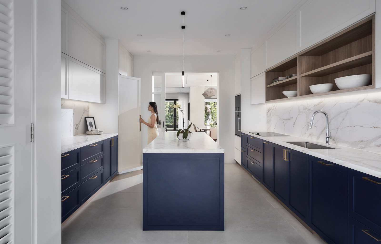 The kitchen introduces a bold pop of colour with navy blue cabinetry