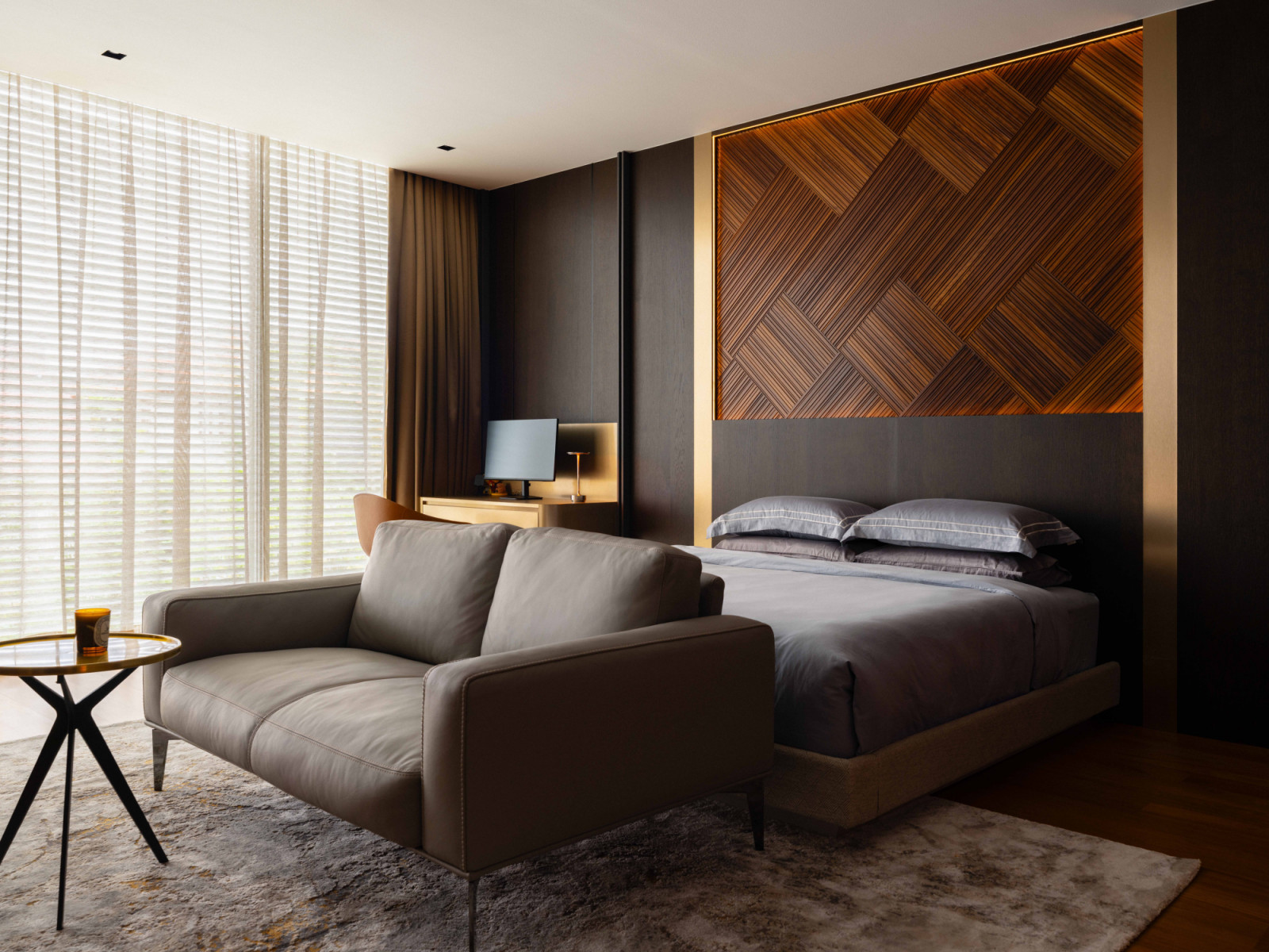 The son’s moody bedroom pairs a woven timber feature wall with a dark, enveloping palette and a Cierre leather sofa