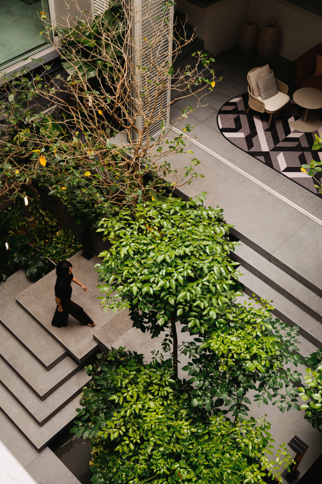 A bird’s-eye view of the bungalow reveals how Designworx Interior Consultant’s furniture and finishes transition seamlessly from the lush courtyard greenery into the well-appointed living spaces beyond