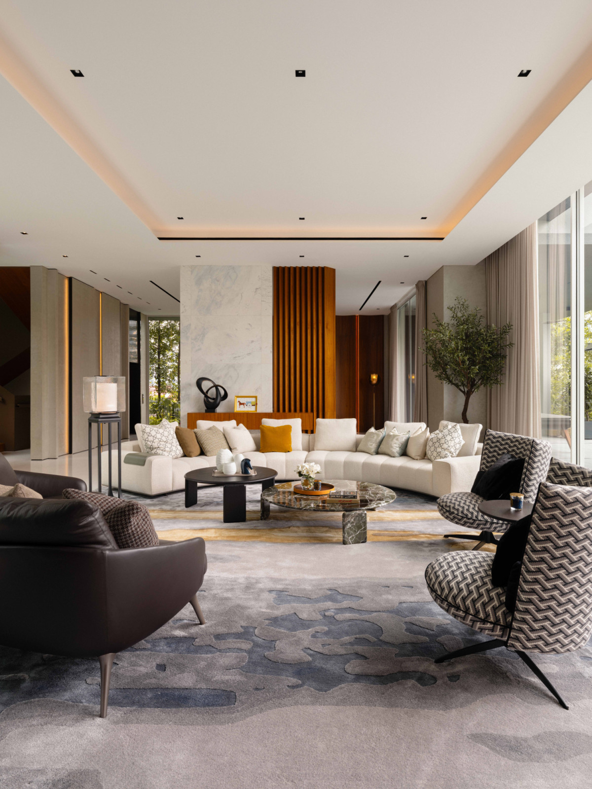 The bungalow’s formal living room centres on a Minotti Goodman semi-circular sofa, with the existing marble and timber partition retained as a considered backdrop