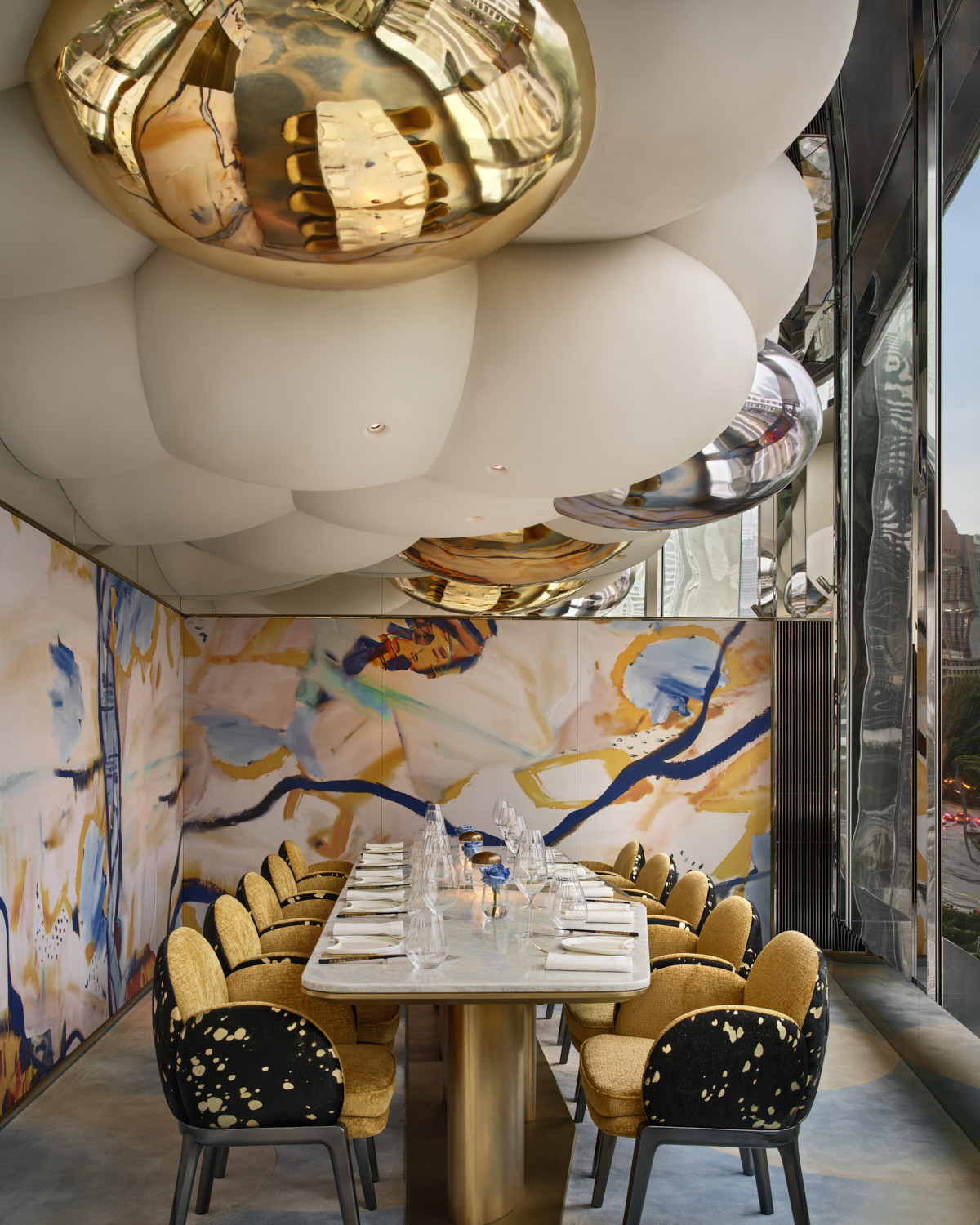 The private dining room at Akira Back Hong Kong, its walls lined with an abstract mural inspired by Chef Akira Back’s mother, Young Hee Back, beneath a sculptural ceiling of matte and polished gold spheres (Photo: Owen Raggett)