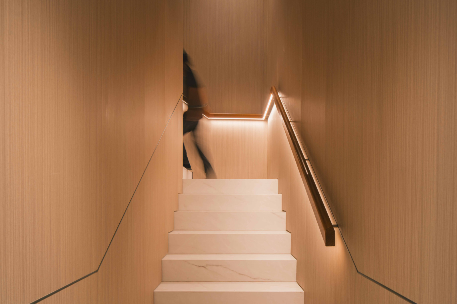 Timber wall panelling, backlit handrails and marble-clad steps complete the elegance of the staircases