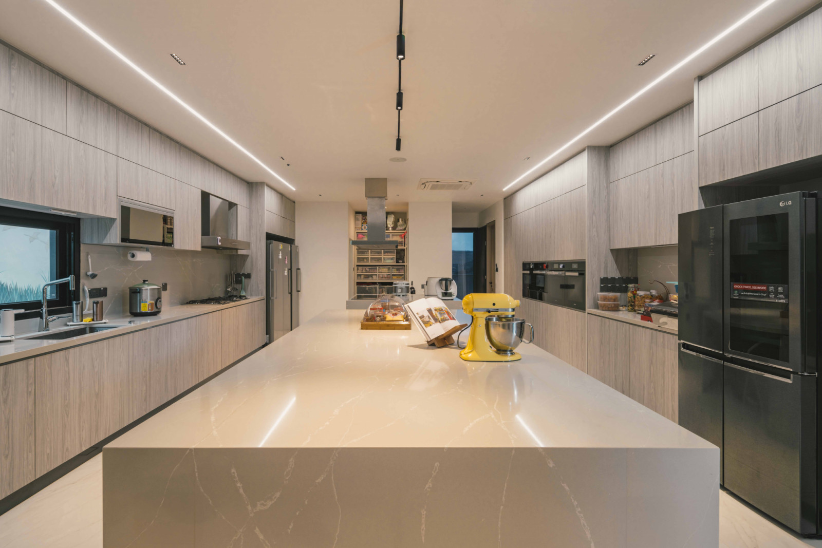 Custom fixtures from Light Image offer ambient and task lighting to provide suitable illumination conditions for the kitchen, which is outfitted with Miele and LG appliances