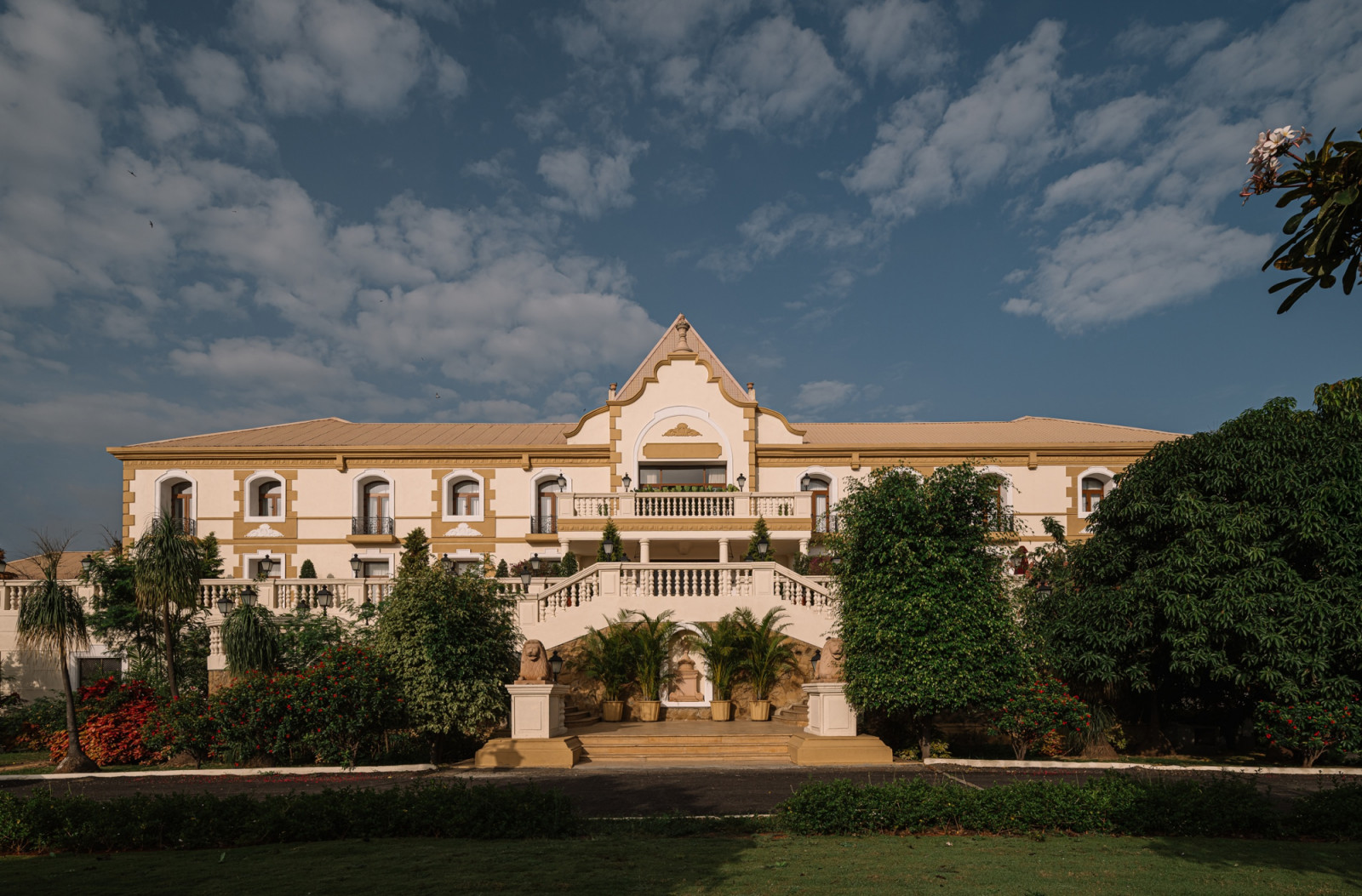 The exterior facade of Hotel Irada in Pune Wine Country, with its cream and ochre colonial-influenced architecture set within landscaped grounds with a formal staircase entrance (Photo: Ishi Sitwala)