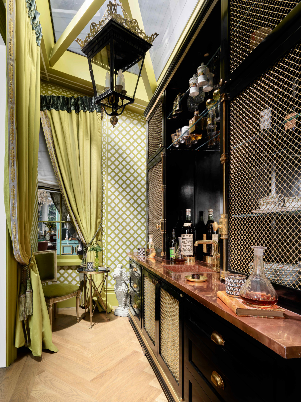The chartreuse-coloured wet bar designed with the charm of a traditional English bar