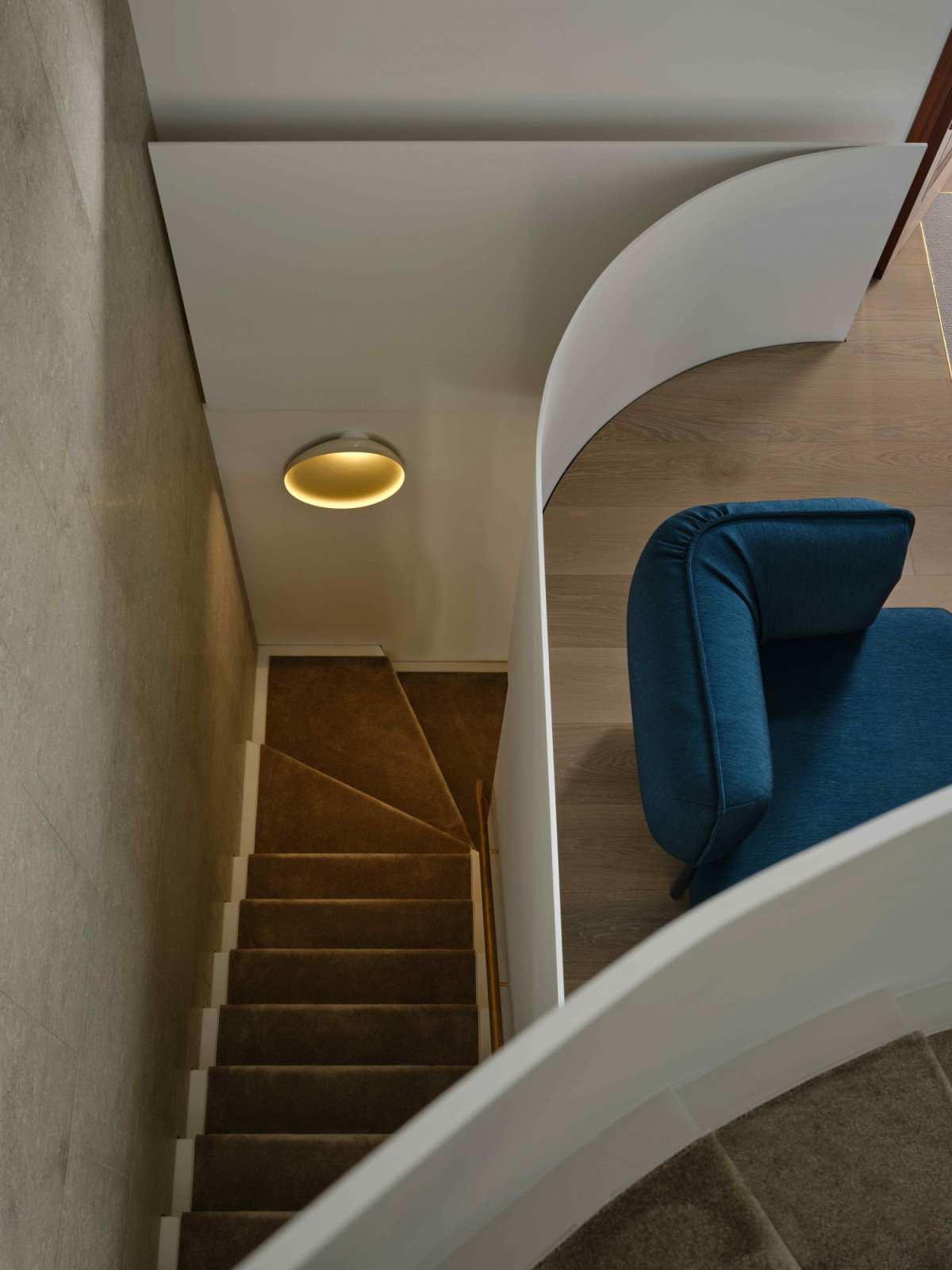 The staircase rises in a continuous sweep through the space